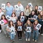 student holding A* signs