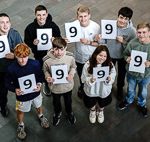 Students holding 9 signs looking happy celebrating their GCSE results